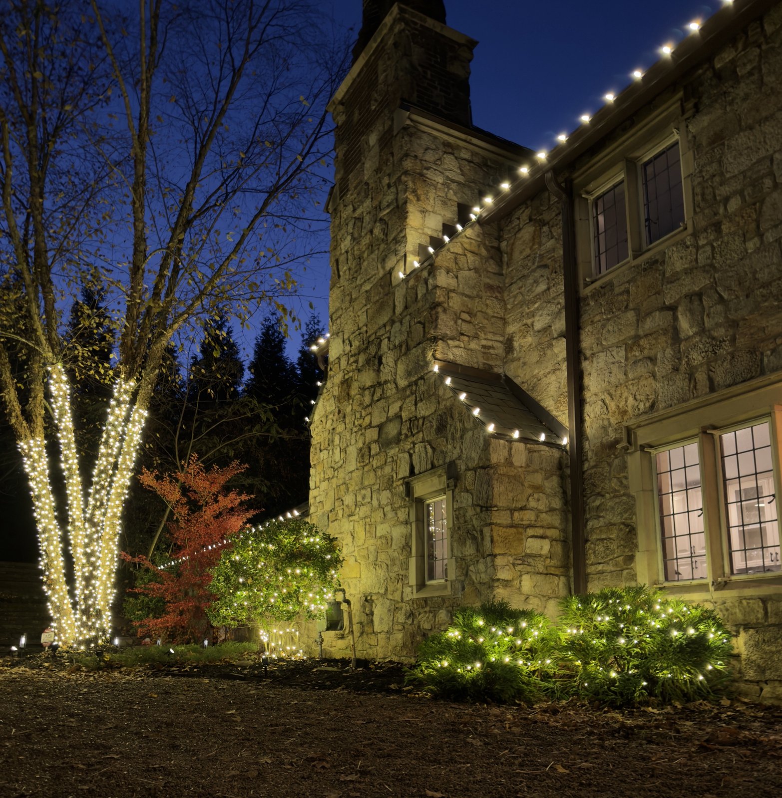 Lit holiday wreath with bow installed on a Knoxville home